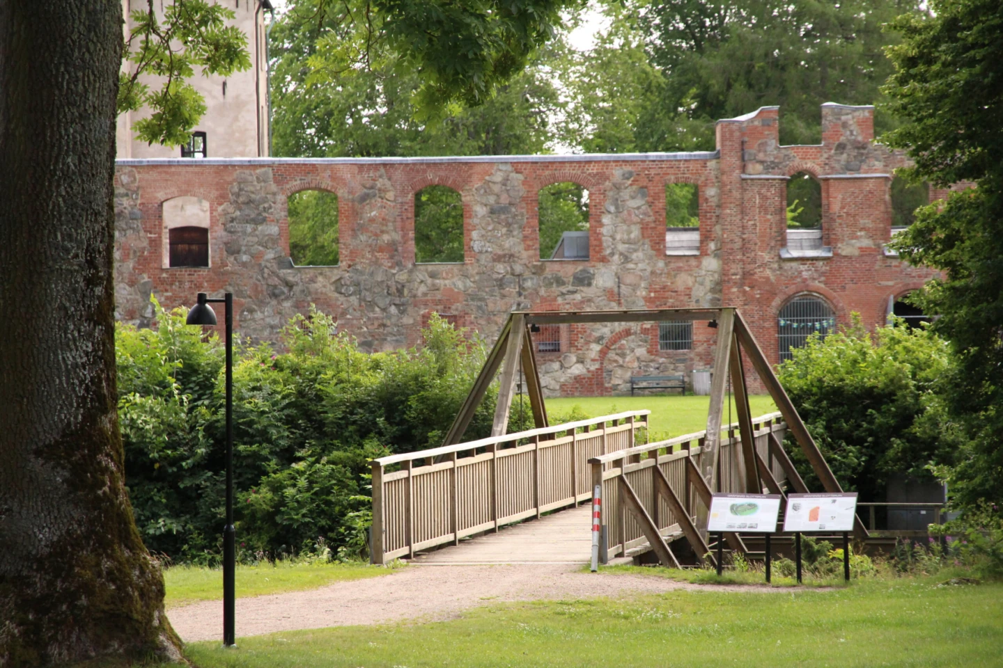 Gräfsnäs slottsruin med träbro i förgrunden.