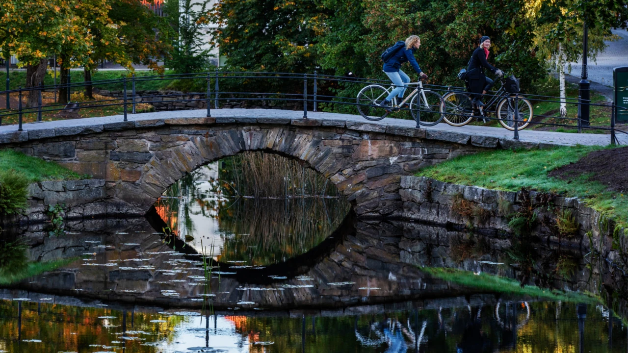 Två personer cyklar över en bro