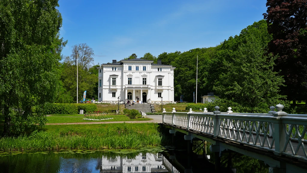 Nolhaga slott med gröna omgivningar sommartid.