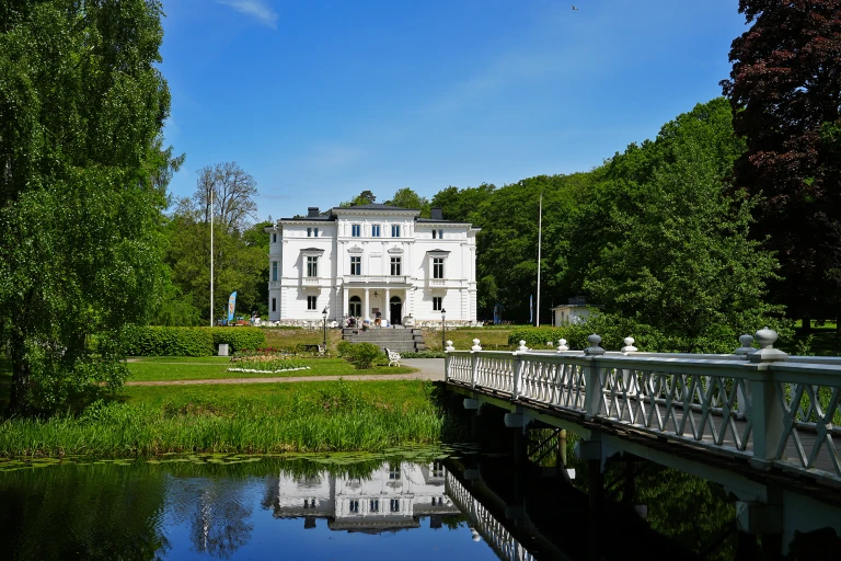Nolhaga slott med gröna omgivningar sommartid.