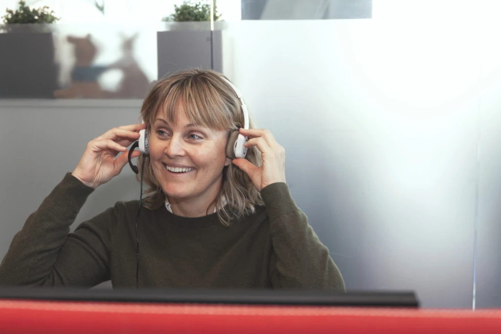 Glad receptionist pratar i sitt headset.