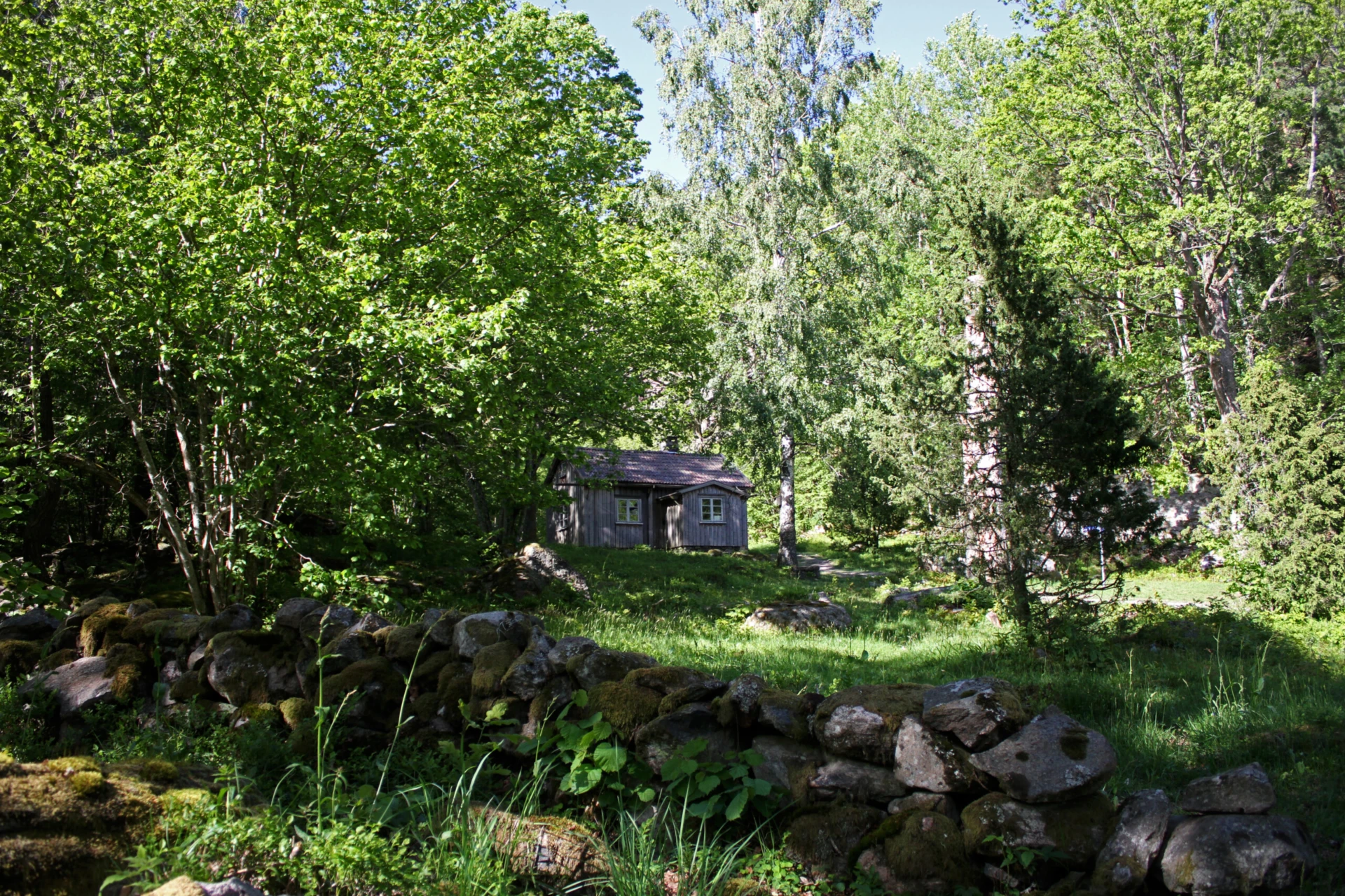 Foto på torp i grönskande ekbacke i Brobacka naturreservat.