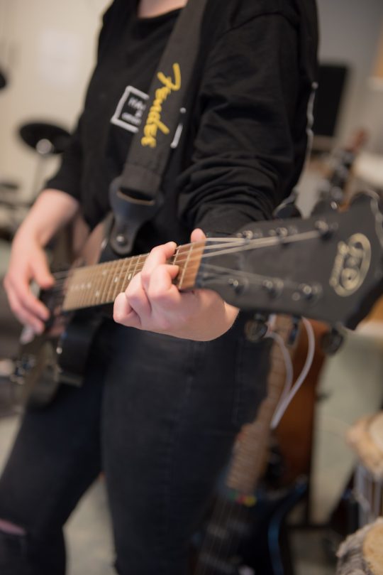 En elev spelar elgitarr.