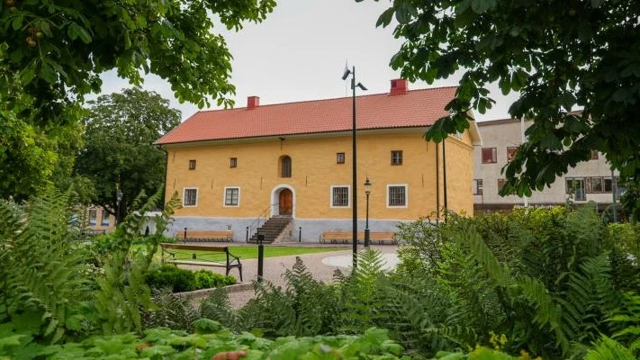 Alingsås museum, ett gult stenhus i en grönskande park i centrala Alingsås