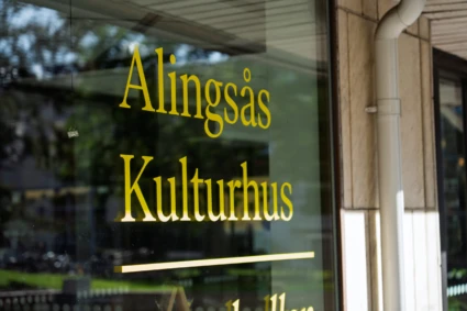 Det står Alingsås Kulturhus på ett fönster. Texten är gul