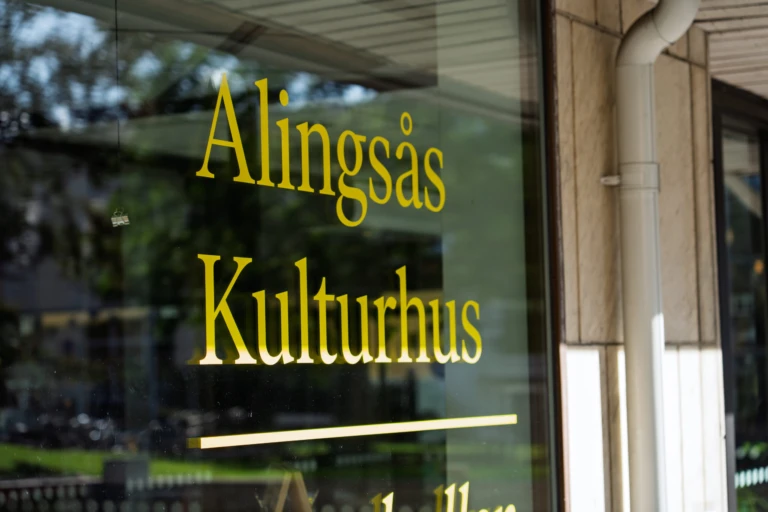 Det står Alingsås Kulturhus på ett fönster. Texten är gul