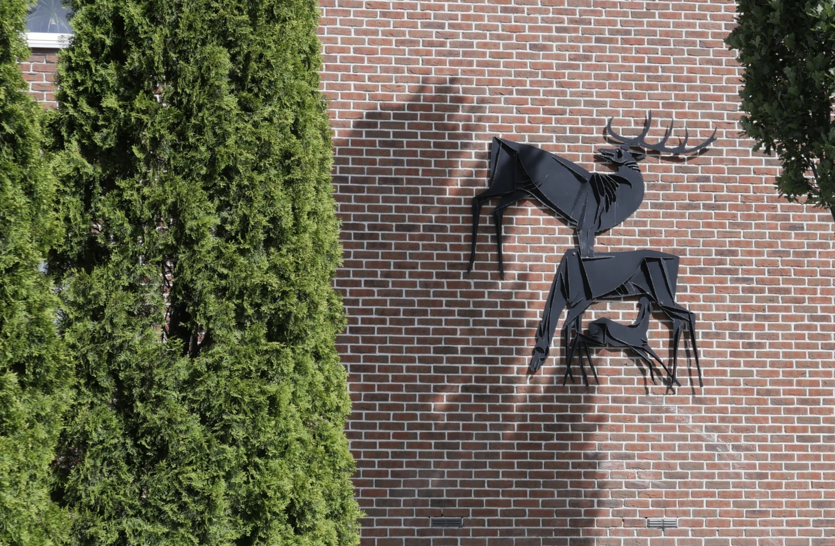 Foto på konstverket "Hjortar", hänger på en tegelvägg.