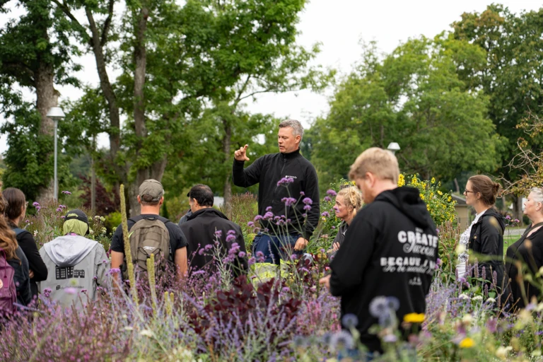 Jesper Lindblad berättar för intresserade besökare i Nolhaga trädgård.