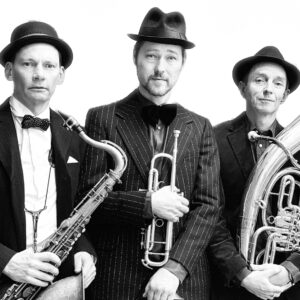 Tre män med hatt, de håller i instrument. Bandet Balkanexpressen.