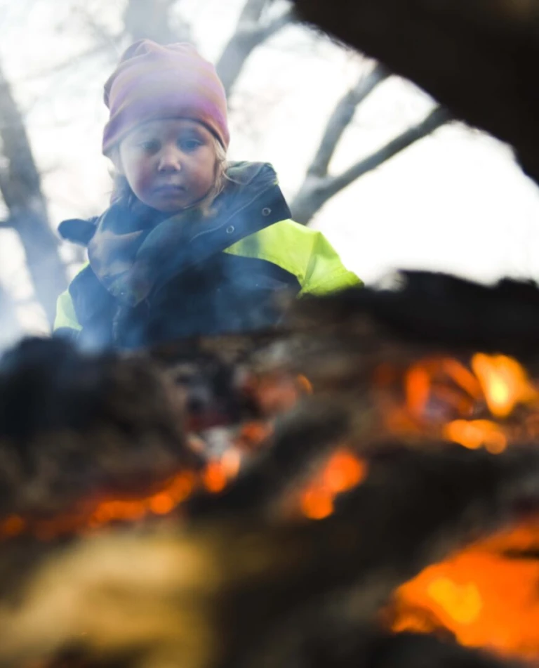 Ett barn som sitter vid en eld