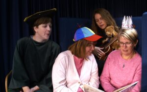 Bibliotekarier som pratar med varandra och läser en bok