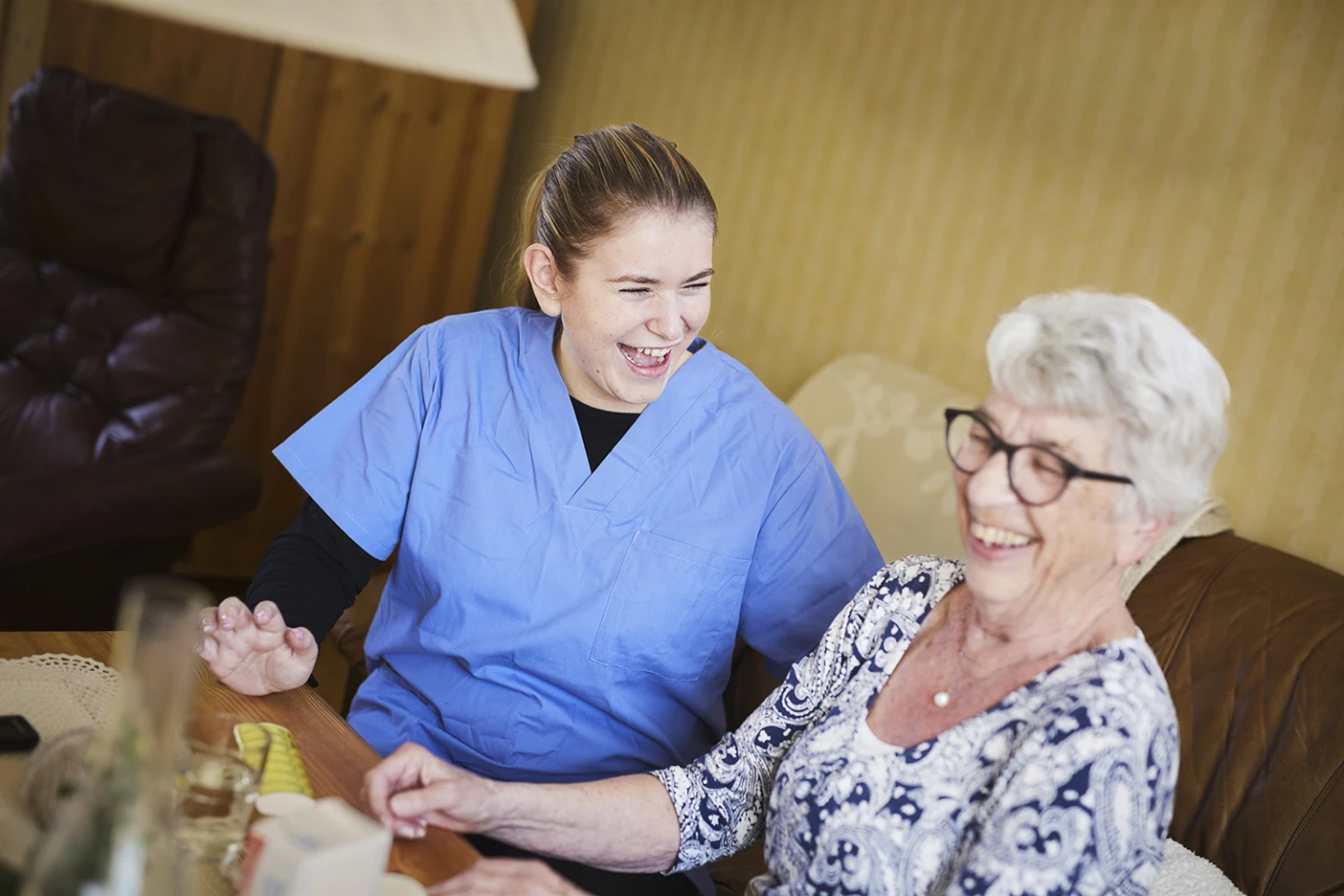 Personal skrattar med äldre brukare.
