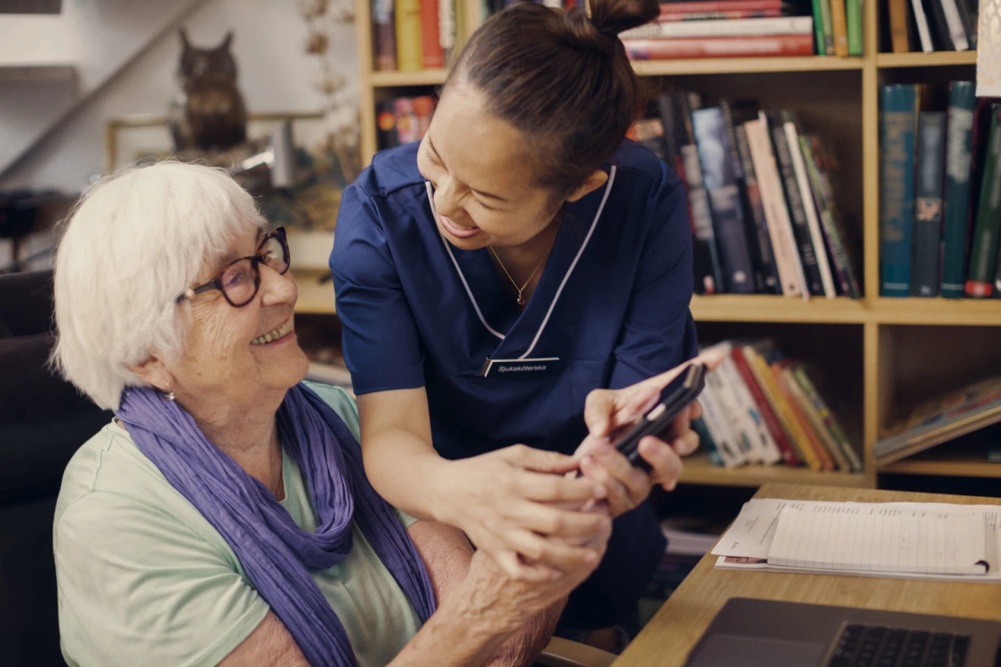 En medarbetare som hjälper en äldre person.