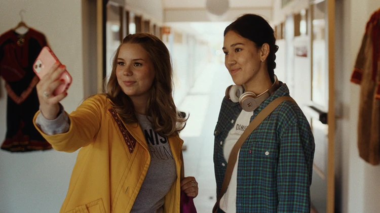 två unga tittar på telefon