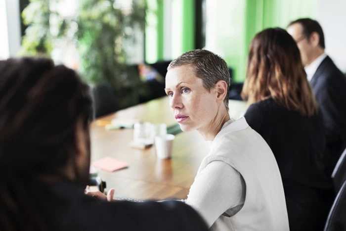 Personer sitter runt ett mötesbord.