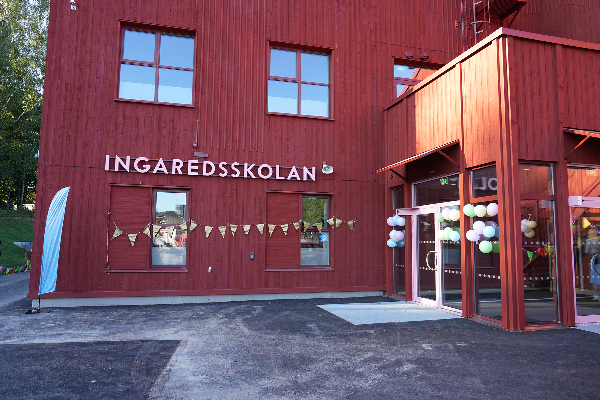 Räd skolbyggnad med namnet Ingaredsskolan på väggen.