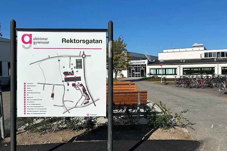Skylt med Alströmergymnasiets byggnader